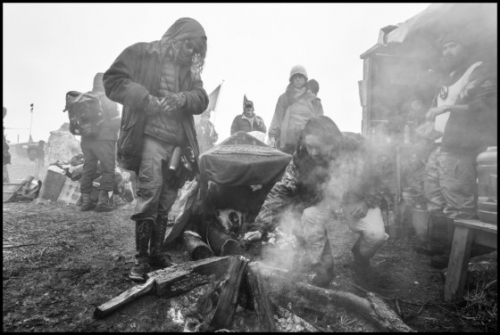 Larry Towell USA. North Dakota. February 22, 2017. Oceti Sakowin Camp. Water Protectors pray at a sacred fire after a ceremony on the day that they were ordered to leave the camp.jpg